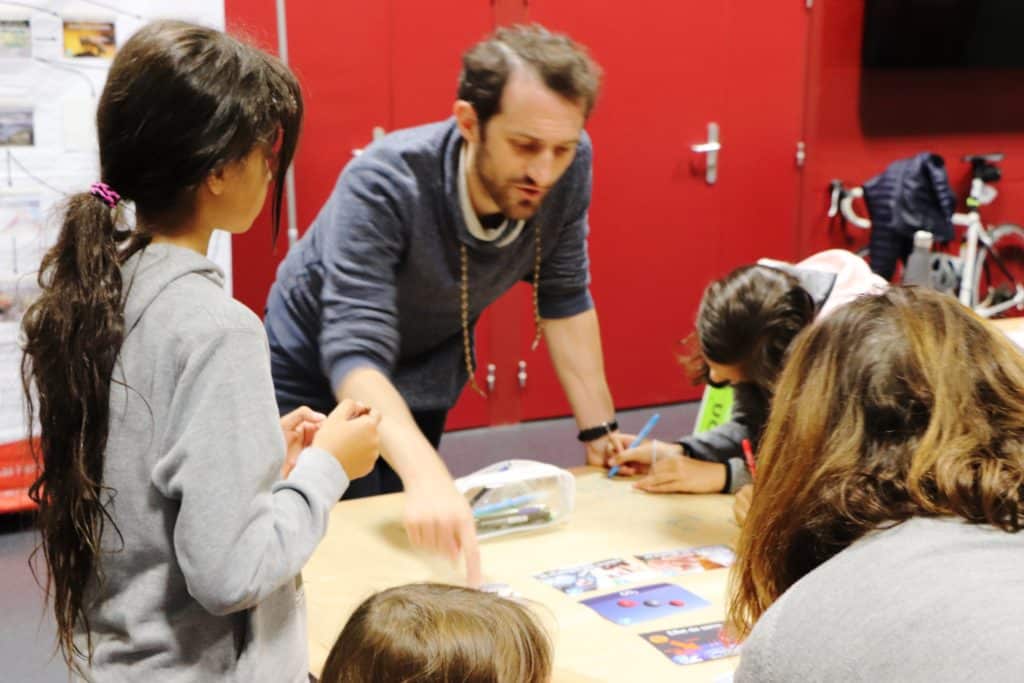 Quentin, fresqueur, anime une fresque du climat junior pour des enfants en visite aux Cours d'eau d'H2O Sans Frontières.