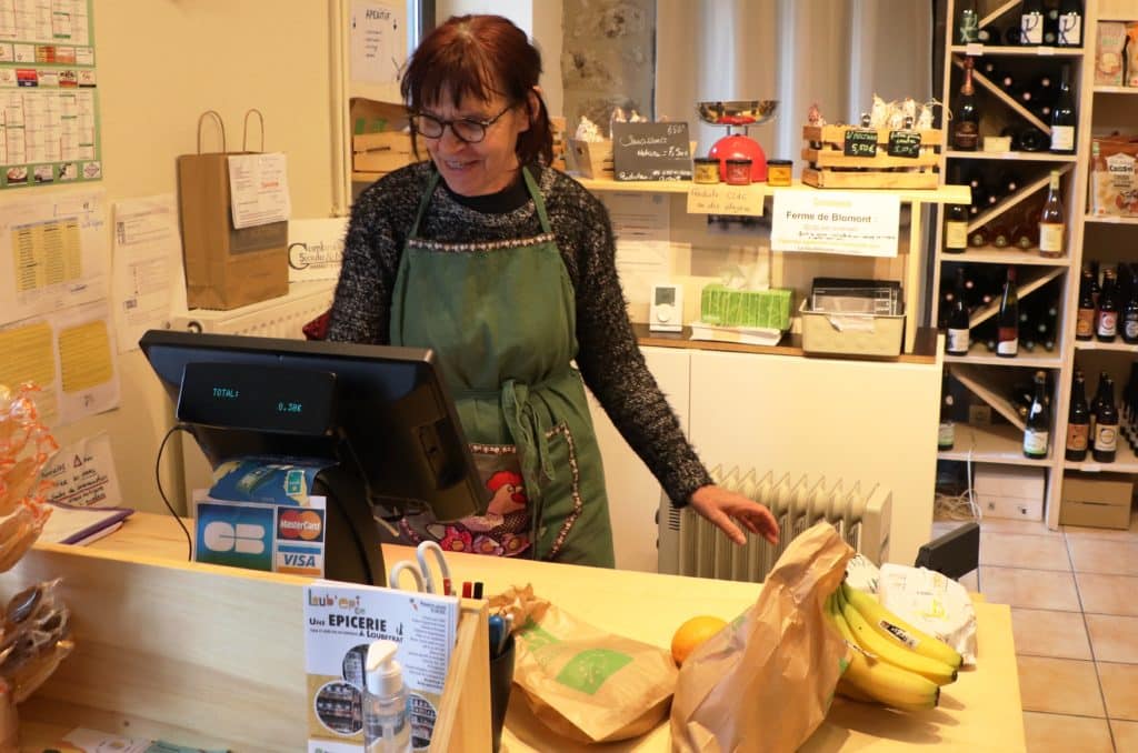 Michèle, bénévole, à la caisse de l'épicerie associative