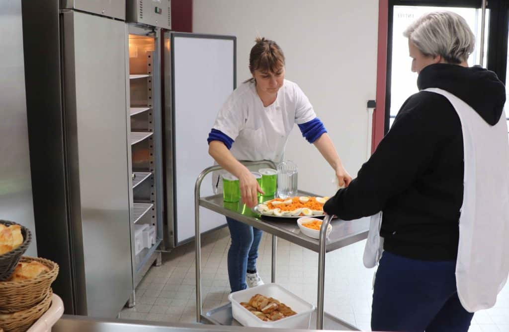 Virginie Vial dans la cuisine de la cantine avec Marie-Charlotte