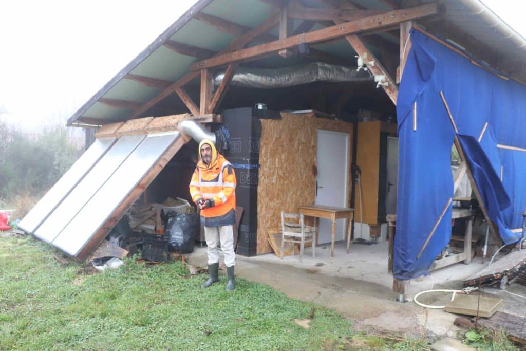 Dominique devant le petit bâtiment du séchoir